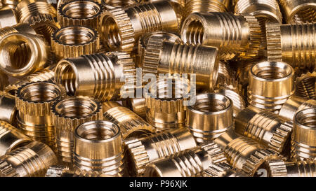 Glänzend Bronze gewindebuchsen als Hintergrund. Nahaufnahme der dekorativen Textur aus einem Haufen von goldenen Metallteilen. Idee, Bau, Bauen, Hardware. Stockfoto