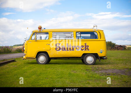 Gelbe Volkswagen Wohnmobil mit Saltrock Logo auf der Seite lackiert Stockfoto