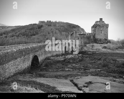 Schöne Dämmerung über Loch an Eilean Donan Castle in Schottland, niedriger Wasserstand Balg steinerne Brücke. Stockfoto