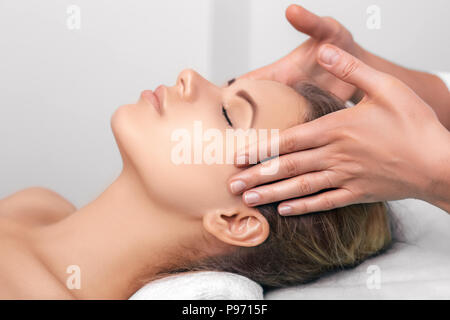 Junge Frau immer ein Kopf Massage im Spa. Gesichtsmassage mit perfekt sauber und frische Haut Stockfoto