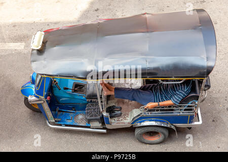 Ein Tuk Tuk Fahrer wartet für Kunden auf der Straße von Chiang Mai, Thailand. Stockfoto