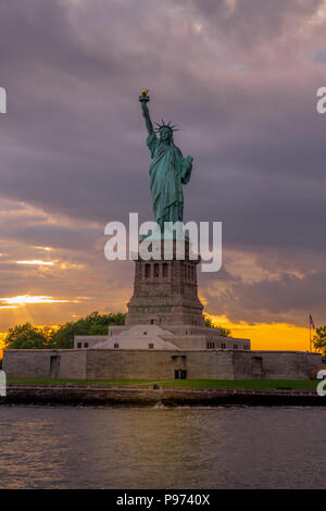 Sonnenuntergang Blick auf die Freiheitsstatue im New Yorker Hafen Stockfoto