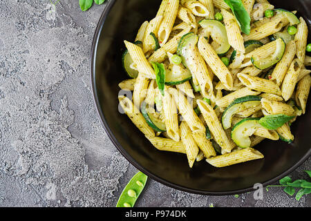 Nudeln mit Pesto, Zucchini, Erbsen und Basilikum. Italienisches Essen. Ansicht von oben. Flach. Stockfoto