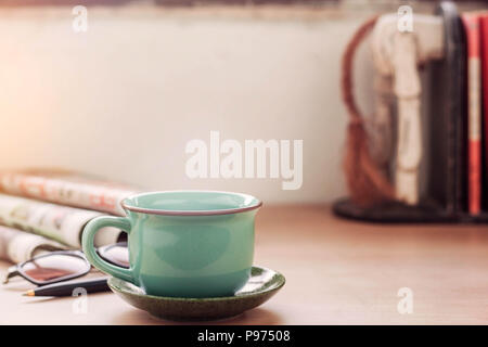 Tasse Kaffee und die Zeitung auf dem Schreibtisch. Stockfoto