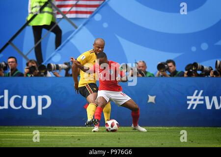 Juli 14, 2018, St, Petersburg, Rußland. Raheem Sterling (10) von England und Vincent Unternehmen Belgiens für den Ball während der FIFA WM 2018 Russland Übereinstimmung zwischen England und Belgien am Stadion St. Petersburg, Russland konkurrieren. Shoja Lak/Alamy leben Nachrichten Stockfoto