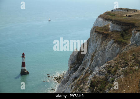 Beachy Head, Großbritannien - 14 Juli 2018: Tourist auf Beachy Head Klippe Beachy Head Lighthouse 162 Meter unterhalb an einem heißen Sommertag gesehen Am 14. Juli 2018. Erhöhte Temperaturen bis zu 27 Grad und wird voraussichtlich hoch für einen Monat zu bleiben. Die Klippe, den höchsten Chalk Sea Cliff in Großbritannien steigt auf 162 Meter über dem Meeresspiegel und leider einer der berüchtigtsten Selbstmord Spots der Welt. Quelle: David Mbiyu Stockfoto