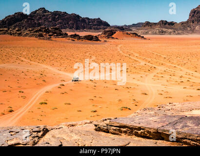 4x4-Fahrzeug und Titel in weite Öde Weite des Wadi Rum wüste Tal mit Bergen, Jordanien, Naher Osten Stockfoto