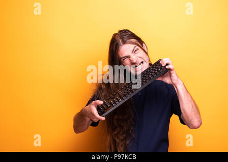 Erwachsene Männchen machen lustige Gesichter mit Tastatur Stockfoto
