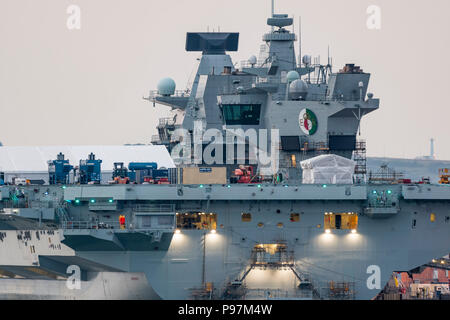 HMS Queen Elizabeth Flugzeugträger, größten und neuesten Kriegsschiff der Royal Navy, in der Dämmerung in den Docks von Portsmouth, Hampshire, England, UK. Stockfoto