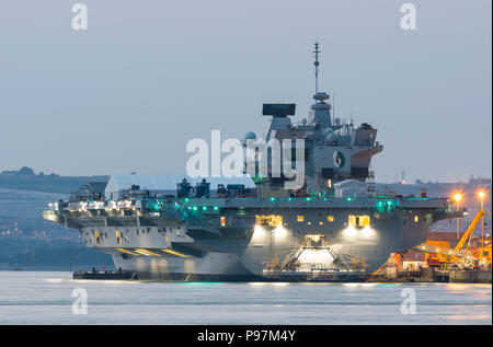 HMS Queen Elizabeth Flugzeugträger, größten und neuesten Kriegsschiff der Royal Navy, in der Dämmerung in den Docks von Portsmouth, Hampshire, England, UK. Stockfoto