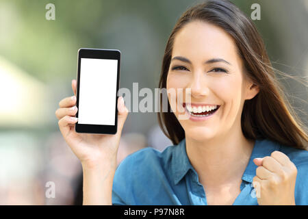 Aufgeregt Frau zeigt einen leeren Bildschirm "Telefon" Mock Up auf der Straße Stockfoto