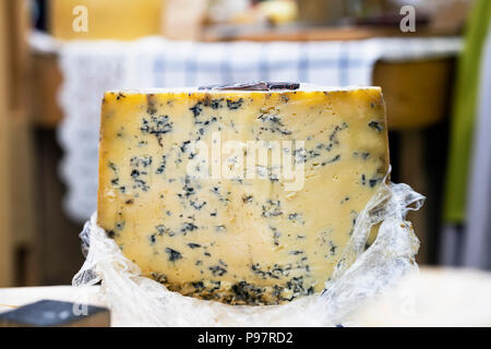 Große Käse Rad mit blauen Schimmel an der Theke, bunte Farben. Gastronomische Leckerbissen Produkte auf dem Markt begegnen, realen Szene in Lebensmittelmarkt Stockfoto