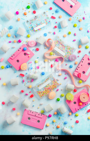 Rosa-Kassetten in einem süßen Klänge Konzept. Bonbons, besprüht und Marmeladen auf hellem Hintergrund mit kopieren. Pastellfarben, flach Stockfoto