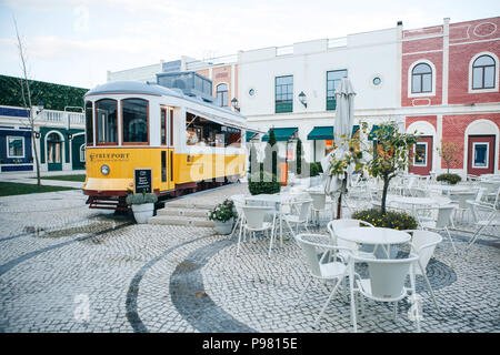 Lissabon, 18. Juni 2018: Eine originelle und authentische Street Cafe in der altmodischen traditionelle Portugiesische gelbe Straßenbahn neben dem Fashion Outlet genannt Stockfoto