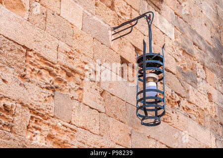 Schwarzes Eisen Glühbirne auf Block gelb Burg rauhe Wand Stockfoto