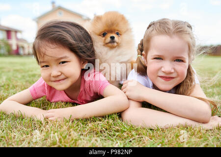 Zwei kleine Mädchen Posieren mit Welpen im Freien Stockfoto