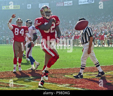 Januar 15, 1994, San Francisco, Kalifornien, USA - San Francisco 49ers gegen New York Riesen am Candlestick Park Samstag, 15. Januar 1994. 49ers Beat Riesen 44-3. San Francisco 49ers zurück läuft Ricky Watters (32) feiert Touchdown. (Bild: © Al Golub über ZUMA Draht) Stockfoto