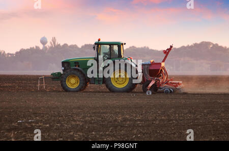 Traktor auf dem Feld bei Sonnenuntergang Stockfoto