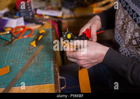 Skinner arbeiten mit Leder Gürtel Stockfoto