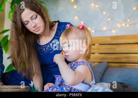 Portrait von lustigen, kleinen Mädchen und ihre Mutter zu Hause Stockfoto