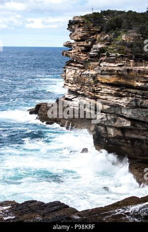 Ozean Wellen auf schroffen Felsen Felswand Stockfoto