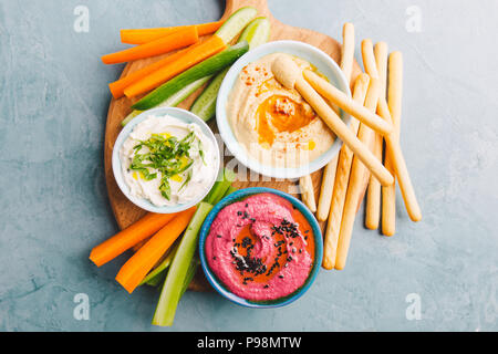 Appetitliche vegetarische Gesunde dips Saucen in kleinen Schälchen mit geschnittenen Gemüse auf Schneidebrett. Blick von oben. Gesunde detox Weight Loss Konzept. Stockfoto