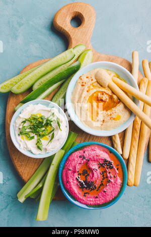 Appetitliche vegetarische Gesunde dips Saucen in kleinen Schälchen mit geschnittenen Gemüse auf Schneidebrett. Blick von oben. Gesunde detox Weight Loss Konzept. Stockfoto