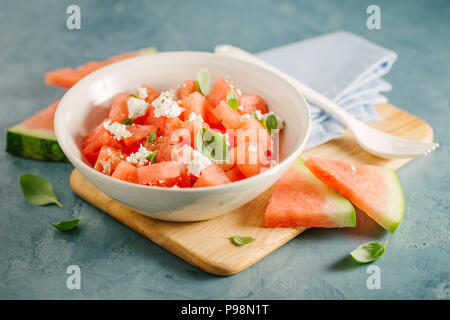 Frische leckere Sommer Salat mit Wassermelone und Feta Käse würfeln, Basilikum in der Schüssel. Serviert und bereit zu essen. Reinigen Detox Weight Loss Konzept Stockfoto