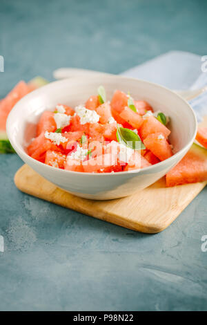 Frische leckere Sommer Salat mit Wassermelone und Feta Käse würfeln, Basilikum in der Schüssel. Serviert und bereit zu essen. Reinigen Detox Weight Loss Konzept Stockfoto