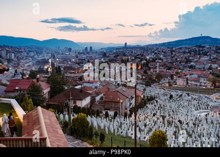 Blick über die wunderschöne Stadt Sarajevo bei Sonnenuntergang von Žuta Tabija (Gelb Festung). Die kovači Friedhof im Vordergrund gesehen werden. Stockfoto