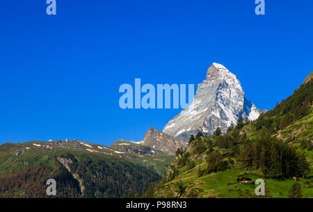 Blick auf den ikonischen schneebedeckten Gipfel des Matterhorn und Ausläufern von Zermatt, Wallis, Schweiz angesehen mit klaren blauen Himmel Stockfoto