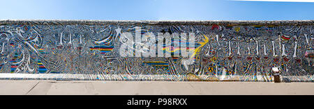 Berlin, Deutschland - Juli 2018: Großes Panorama der Berliner Mauer / East Side Gallery mit einem Teil der Gemälde von schamil Gimajev' Welten, Menschen, wir s Stockfoto