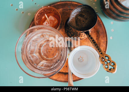 Bosnischen Kaffee serviert in Mostar. Ein cezve Kaffee mahlt und heißes Wasser, ein Glas Wasser und ein Gelee süß. Stockfoto
