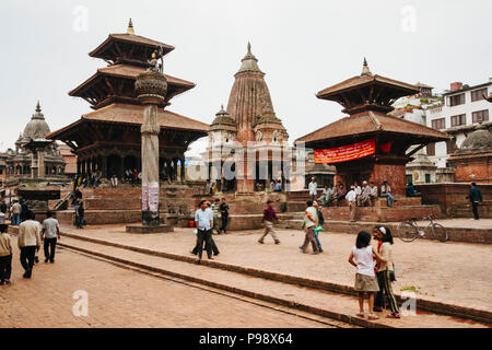 Kathmandu Tal, Kathmandu, Nepal: Passanten Spaziergang entlang der Unesco Patan Durbar Square. Bhimsen, Vishwanath und Krishna Tempel sind in Ba gesehen Stockfoto