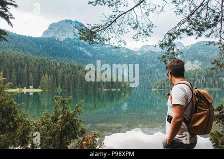 Ein männlicher Touristische stoppt den vollkommen klar, noch See im Nationalpark Durmitor, Montenegro zu bewundern. Stockfoto