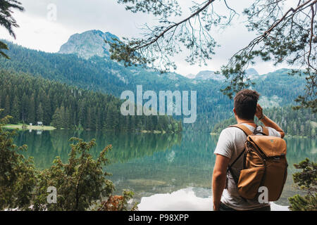 Ein männlicher Touristische stoppt den vollkommen klar, noch See im Nationalpark Durmitor, Montenegro zu bewundern. Stockfoto