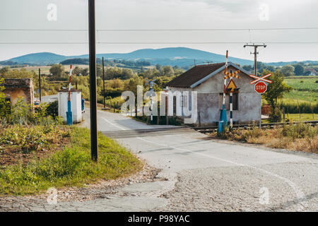 Ein kleines Haus mit Gemüsegarten, neben einem Bahnübergang in der serbischen Landschaft Stockfoto