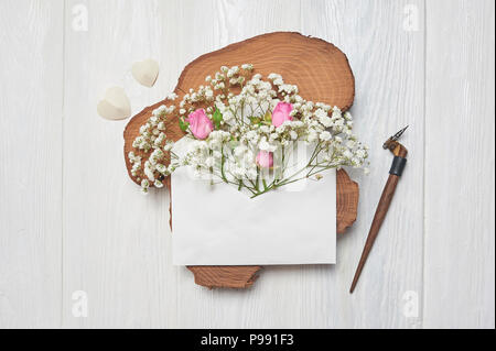 Kalligrafische Feder einen Umschlag mit Blumen und einem Brief, Grußkarte für Valentines Tag mit Platz für Ihren Text. Flach, Ansicht von oben Foto Mock up Stockfoto