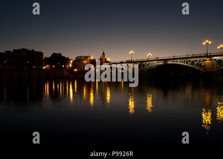 Die fantastische Triana Brücke mit auf dem Guadalquivir in Sevilla, Spanien, ein wunderbarer Sommer Nacht Stockfoto