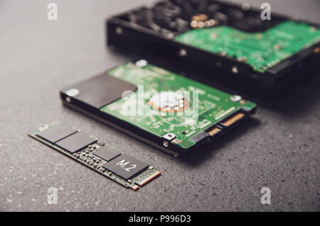 Laufwerke angeordnet auf einem Tisch aus Stein als Symbol für die Entwicklung der Technologie von HDD zu SSD Stockfoto