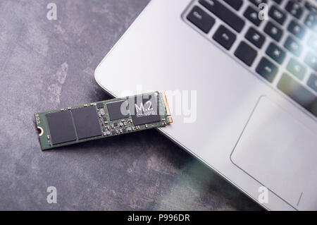 Schnelle M.2 Solid State Drive liegt auf einer modernen Aluminium Laptop Stockfoto