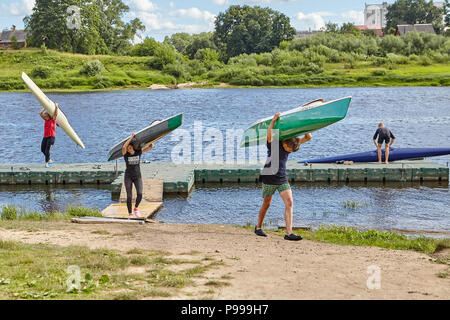 Junge Fans von Sport rudern weg Kajaks aus westlichen Dwina Fluss, dass sie auf den Schultern ausgeliefert. Stockfoto