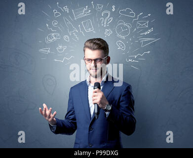 Geschäftsmann sprechen in das Mikrofon mit gemischten Doodles über seinem Kopf Stockfoto