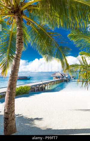 Malediven Insel, Luxus Water Villas Resort und hölzernen Pier. Schönen Himmel und Wolken und Strand Hintergrund für Sommer Urlaub und Reisen Stockfoto