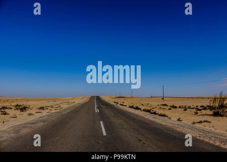 Gerade Straße über den Horizont durch die karge Landschaft der Wüste Namib in Namibia Stockfoto