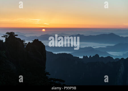 Sonne aus dem östlichen Smog über dem Meer von Wolken in Huangshan Gebirge im Süden der Provinz Anhui im Osten Chinas. Stockfoto