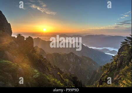 Bunte Sonnenaufgang über dem Meer der Wolken auf einem der Gipfel von Huangshan Gebirge im Süden der Provinz Anhui im Osten Chinas. Stockfoto