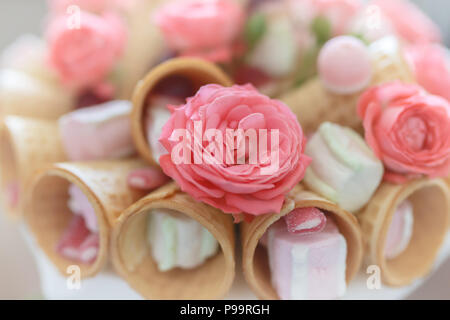 Blumenstrauß aus Blüten von Rosen, Waffeln, Süßigkeiten und Marshmallows Nahaufnahme Stockfoto