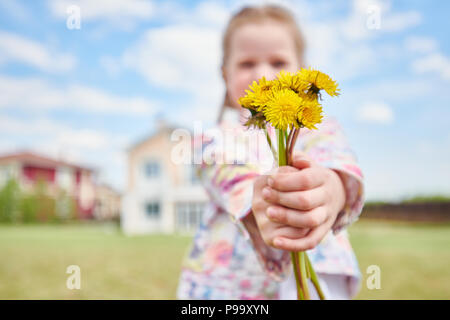 Mädchen mit Blumenstrauß aus Löwenzahn Stockfoto