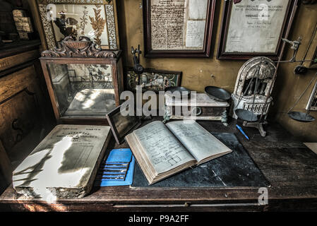 Die Arbeit Tabelle der Apotheker mit Waagen und ein Heft im hinteren Raum der Eingangshalle des alten Apotheke und Apotheke "Farmacia di S. Maria della Scala' in Piazza della Scala im Viertel Trastevere, Rom, Italien Stockfoto